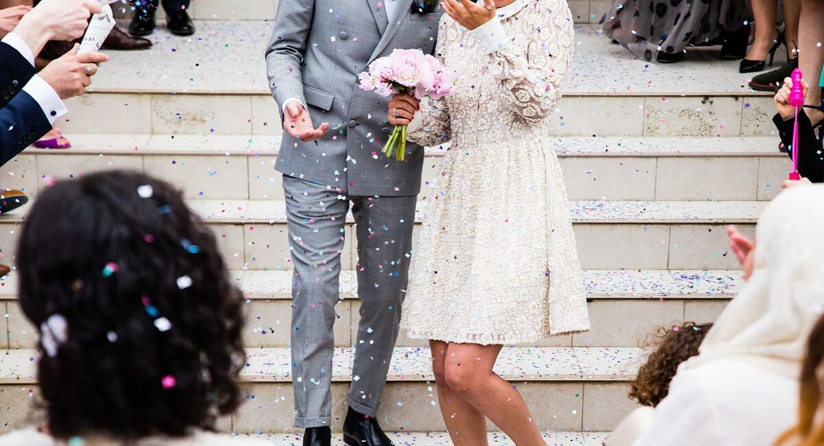 Wedding Loans | just married couple walking down the steps with confetti
